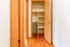 Inviting wooden hallway leading to an elegantly organized closet, complete with modern shelving options.