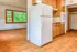 Inviting kitchen and living space with warm wooden floors, abundant natural light from large windows, and classic hardwood cabinetry.