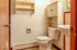 Charming bathroom with vintage tile flooring, elegant pedestal sink, and ample wooden storage.