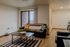 Modern living room with cozy black sofa, colorful throw pillows, and natural light from large patio window, perfect for relaxation and inspiration.