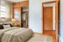 Cozy bedroom with natural wood accents, elegant lighting, spacious closet, and soft neutral tones for a serene ambiance.