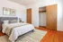 Inviting bedroom with a modern design, featuring a cozy bed, elegant wooden flooring, and a spacious closet.