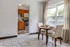 Charming dining area with natural light, featuring cozy table setup for two, connected to a modern kitchen with wooden cabinetry and stainless steel appliances.
