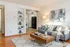Bright and inviting living room with elegant decor, cozy gray sofa, modern wooden coffee table, and artistic wall art.