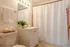 Bright and inviting bathroom featuring modern fixtures, plush towels, a soothing candle, and a fresh green plant for a spa-like experience.
