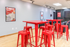 Vibrant communal area featuring stylish red high tables and stools, perfect for social gatherings or casual meetings.
