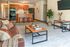 Contemporary living room with elegant decor, cozy seating, and a modern kitchen featuring warm wooden cabinetry and stylish bar stools.