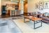 Inviting open-concept living room and kitchen with modern decor and cozy seating, highlighting stylish artwork and a sleek breakfast bar.