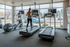 Modern fitness center with treadmills and exercise equipment, featuring a panoramic window view for an energizing workout experience.