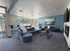 Inviting modern lounge with plush blue seating, a sleek fireplace, and a large window wall offering abundant natural light.