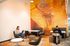 Vibrant lounge area featuring modern furniture, artistic wall mural, and ambient lighting, perfect for relaxing or working.