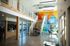 Modern apartment lobby with vibrant mural, open seating, and stylish staircase.