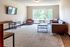 Bright living room with contemporary furniture, large window, and wall-mounted television for a modern apartment vibe.
