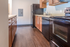 Modern kitchen with sleek black appliances, warm wooden cabinetry, and elegant countertops, creating a stylish cooking space.