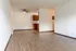 Bright and spacious open-plan living room with modern wood flooring and cozy kitchen area.