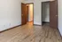 Bright room with wooden flooring and open doors leading to a closet and hallway, perfect for modern living.
