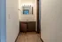 Cozy bathroom area with wooden flooring, featuring a large mirror and sink with under-cabinet storage.