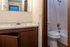 Cozy bathroom with a compact layout featuring a modern sink, mirror, and a bathtub with shower, perfect for minimalist living.