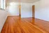 Bright, open living space with polished hardwood floors and clean white walls, perfect for customization.
