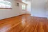 Bright living space with polished hardwood floors, large windows, and natural light creating an airy and inviting atmosphere.