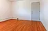 Bright room with elegant hardwood floors and a pristine white door, ideal for customization.