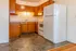 Cozy kitchen featuring warm wooden cabinets, spacious countertops, and a large white refrigerator in a compact layout.
