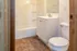 Cozy, bright bathroom with elegant sink vanity, modern fixtures, and warm-toned flooring.