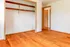 Bright, spacious room featuring gleaming hardwood floors and an open closet, ideal for stylish and functional living.