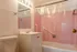 Charming bathroom with vintage pink tile, modern vanity, and bright lighting for a cozy ambiance.