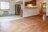Inviting open floor plan with warm wooden flooring, modern kitchen cabinetry, and abundant natural light.