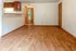 Inviting open-plan living area with warm wooden flooring and natural light.