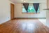 Cozy living room with warm wood flooring, bright window light, and modern atmosphere.