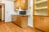 Charming kitchen with warm wooden cabinets, built-in shelves, and sleek countertop ideal for cozy home cooking.