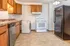 Inviting kitchen with wood cabinetry, modern appliances, and convenient laundry installation.