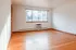 Bright and airy room with elegant hardwood floors and a large window offering natural light.
