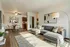 Elegant living room with chic gray sofa, stylish floor lamp, and cozy dining area, exuding modern comfort.