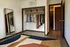 Chic bedroom with open closet showcasing organized clothing, elegant mirror, and modern geometric rug enhancing the space.