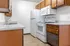 Charming apartment kitchen with classic wooden cabinets, modern appliances, and sleek countertops for a cozy and functional cooking space.
