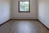 Bright and airy room featuring elegant wood flooring, a large window with a scenic view, and freshly painted walls, perfect for a cozy bedroom or a productive home office.