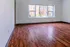 Bright and inviting room featuring elegant wood flooring and a large window offering scenic views.