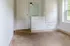 Bright room with built-in white wardrobe, mirror, and ample natural light from large window.