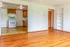 Bright and inviting apartment with open kitchen view, featuring elegant hardwood floors and built-in shelving.