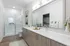 Elegant bathroom with spacious double vanity, sleek glass shower, and modern decor accents.