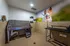 Modern pet grooming room featuring a stainless steel tub, ergonomic design, and vibrant dog mural for a cheerful atmosphere.