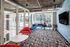 Common area with windows, tables, chairs, seating and large flat-screen TV  at The Henry | Apartments in Tampa, FL
