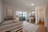 Bright modern bedroom featuring two chic beds, balcony access with outdoor seating, and a convenient ensuite bathroom, perfect for stylish urban living.