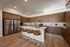Modern kitchen with sleek wooden cabinets, stainless steel appliances, and a central island with stylish seating.