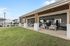 Bright, open-air community gym with modern equipment and inviting outdoor seating, perfect for fitness enthusiasts.