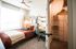 Bright and cozy bedroom with modern decor, featuring a comfortable bed, spacious closet with shelving, and a stylish workspace near a large window.