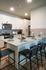 Modern kitchen with sleek countertops, stainless steel appliances, and stylish bar seating, perfect for entertaining.